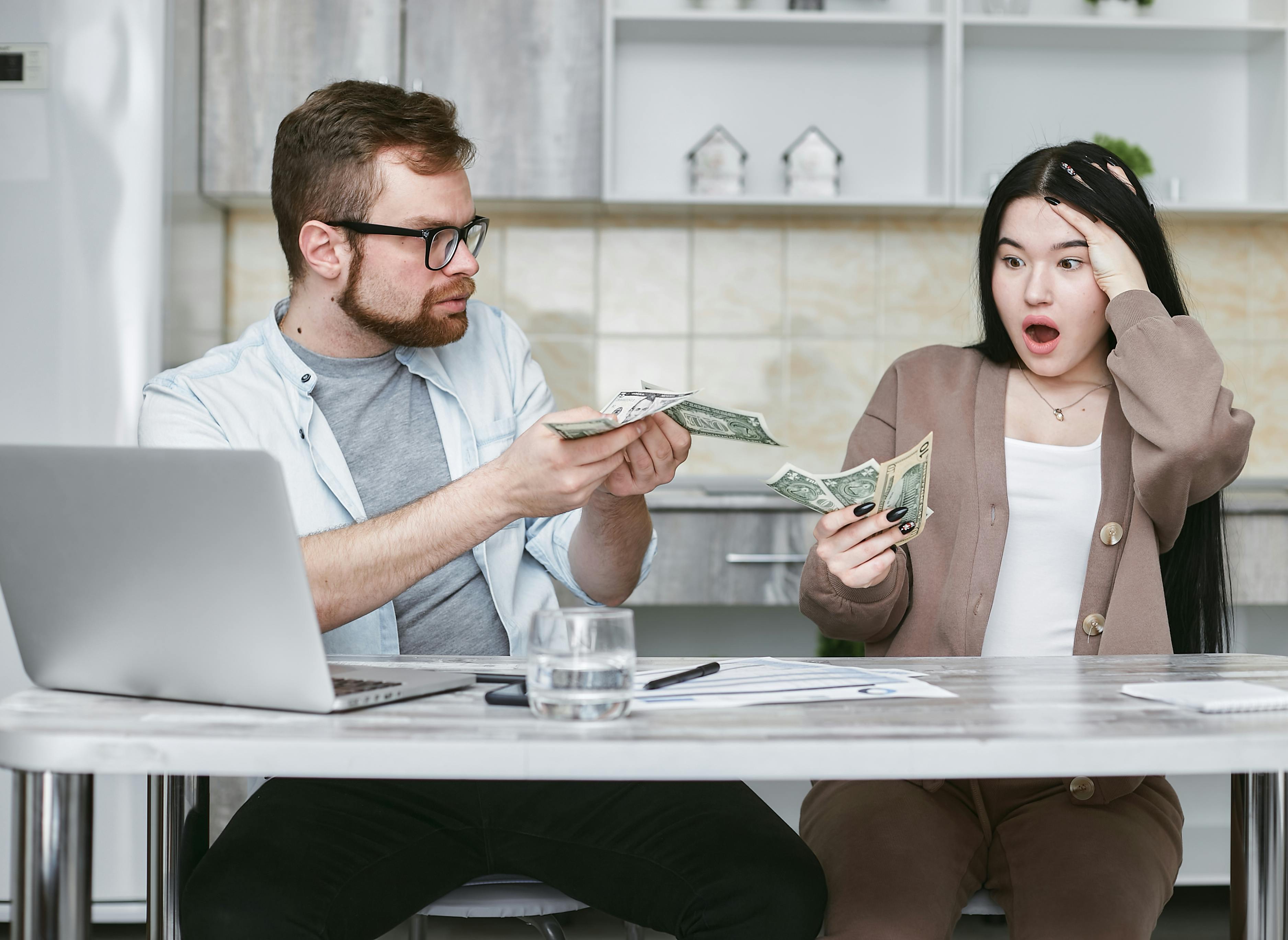 Couple worried about money with house models in the background